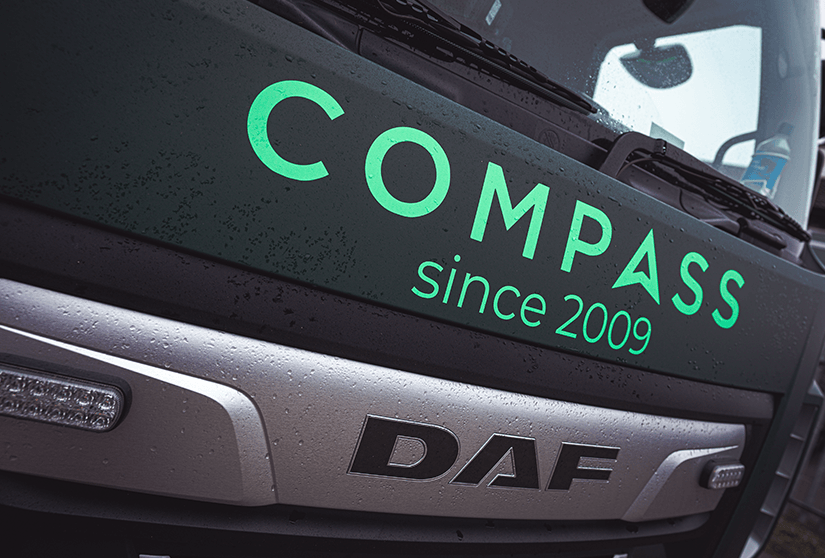 Close-up of a DAF truck with 'COMPASS since 2009' branding on the front.