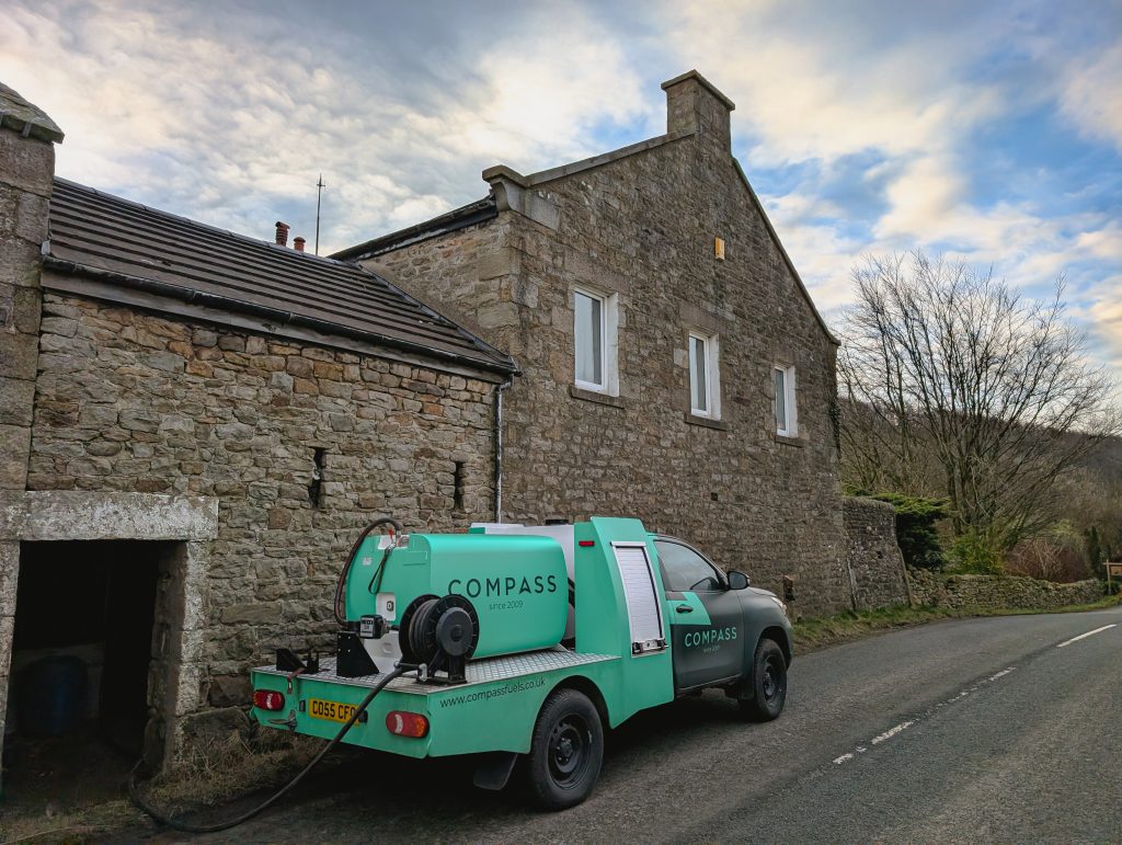 a compass delivery vehicle delivering heating oil to a domestic home customer